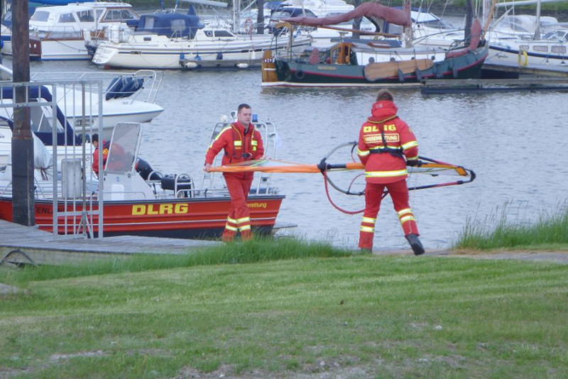Wassrretter bringen das geborgene Surfsegel an Land